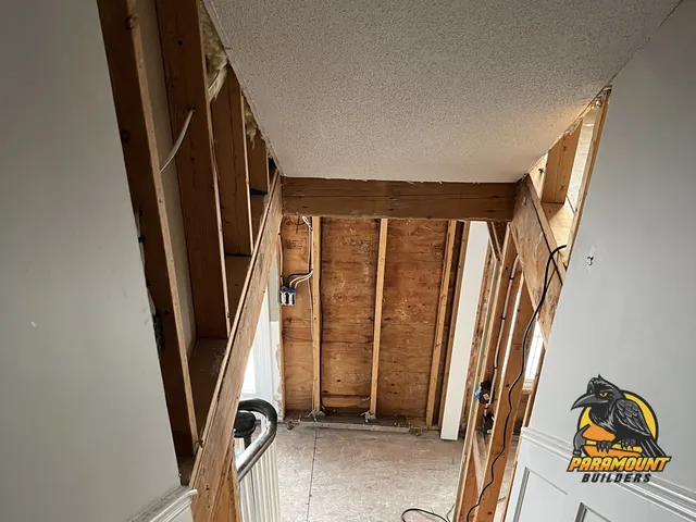 Stairway with adjacent wall opened to studs and insulation removed - Reconstruction, foyer in progress, South Windsor, CT