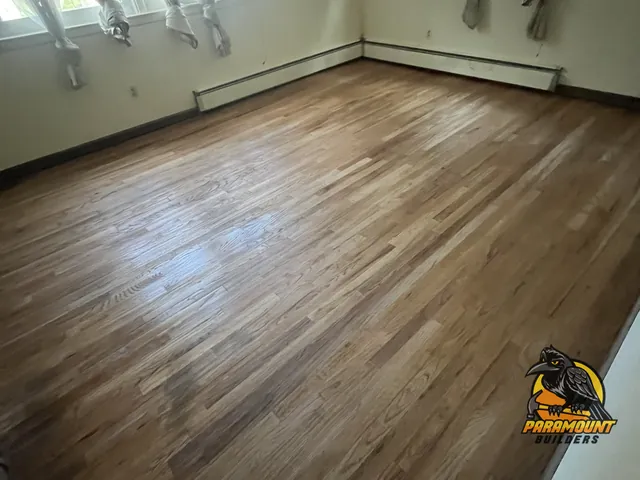Refinished oak floor in empty room with baseboard heat - Reconstruction, home after, Waterbury, CT